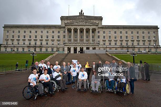 In this handout image provided by LOCOG, Flame Ambassadors from Northern Irish Counties pose outside Stormont during the Paralympic Torch Relay on...