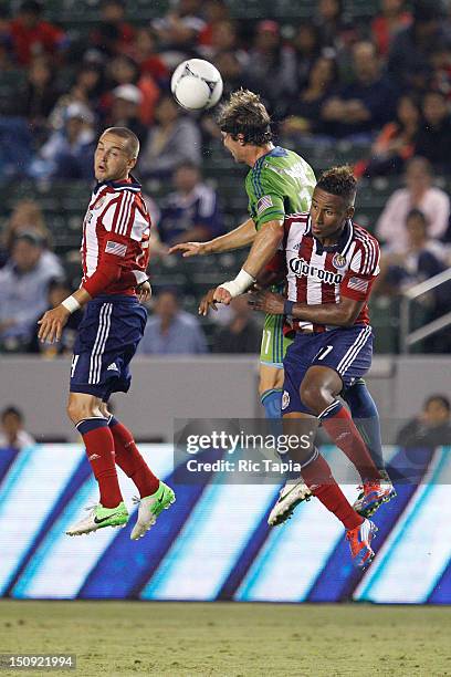Jeff Parke of Seattle Sounders FC heads the ball against Juan Agudelo of Chivas USA during the MLS match at The Home Depot Center on August 25, 2012...