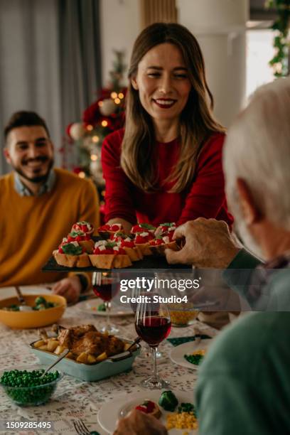 eine mischung aus traditionen und kulturen trifft aufeinander, wenn eine multikulturelle familie das weihnachtsessen in einer harmonischen atmosphäre feiert. - weihnachtsessen stock-fotos und bilder