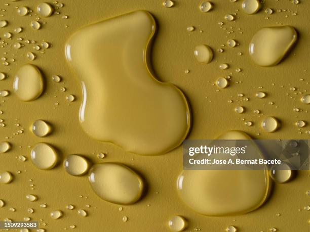 full frame of small drops and splashes of water on a beige background. - puddle stock pictures, royalty-free photos & images