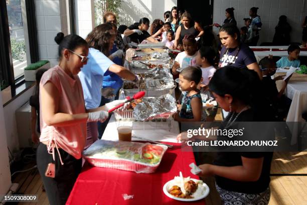 People attend a dinner for asylum seeker families at Romemu Center in New York City on June 27, 2023. The unprecedented arrival of 80,000 asylum...