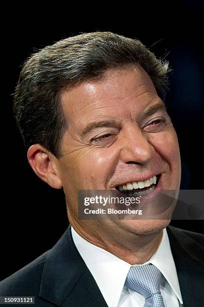 Sam Brownback, governor of Kansas, laughs during a Bloomberg Television interview inside the Bloomberg Link during the Republican National Convention...