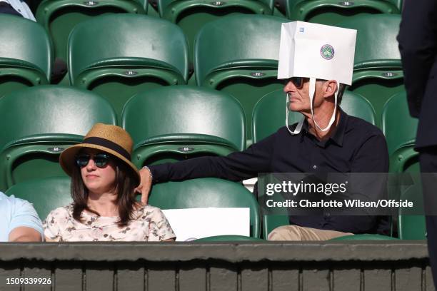 Spectator uses a paper bag as a hat during day four of The Championships Wimbledon 2023 at All England Lawn Tennis and Croquet Club on July 6, 2023...