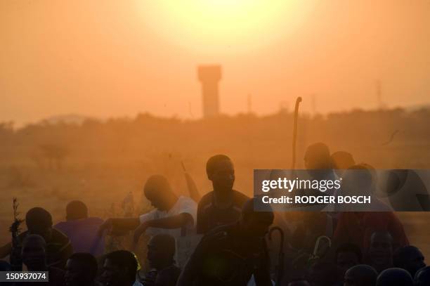 Striking Lonmin mine workers form a group to sing and dance after listening to a report about the state of their wage negotiations on August 29, 2012...