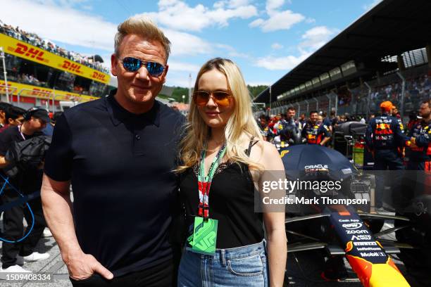 Gordon Ramsay and Holly Ramsay pose for a photo with the car of Max Verstappen of the Netherlands and Oracle Red Bull Racing on the grid prior to the...