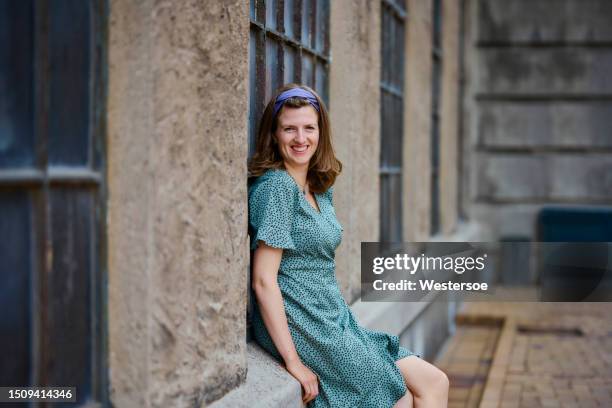 woman in summer dress leaning against rough wall - green dress stock pictures, royalty-free photos & images