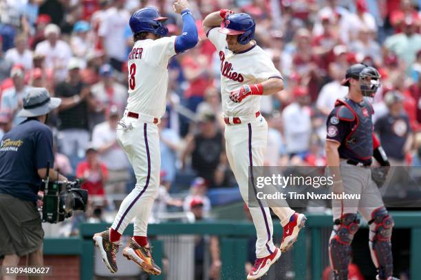 Bryce Harper and J.T. Realmuto of the Philadelphia Phillies react following a two run home run hit by Realmuto during the first inning against the...