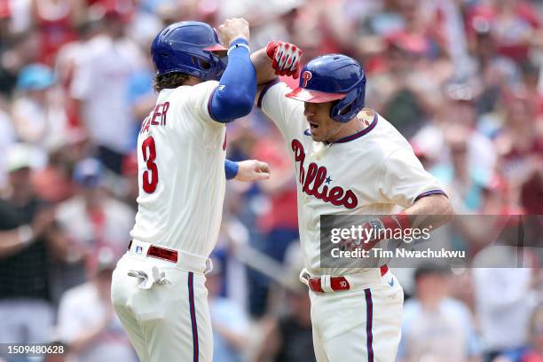 Bryce Harper and J.T. Realmuto of the Philadelphia Phillies react following a two run home run hit by Realmuto during the first inning against the...