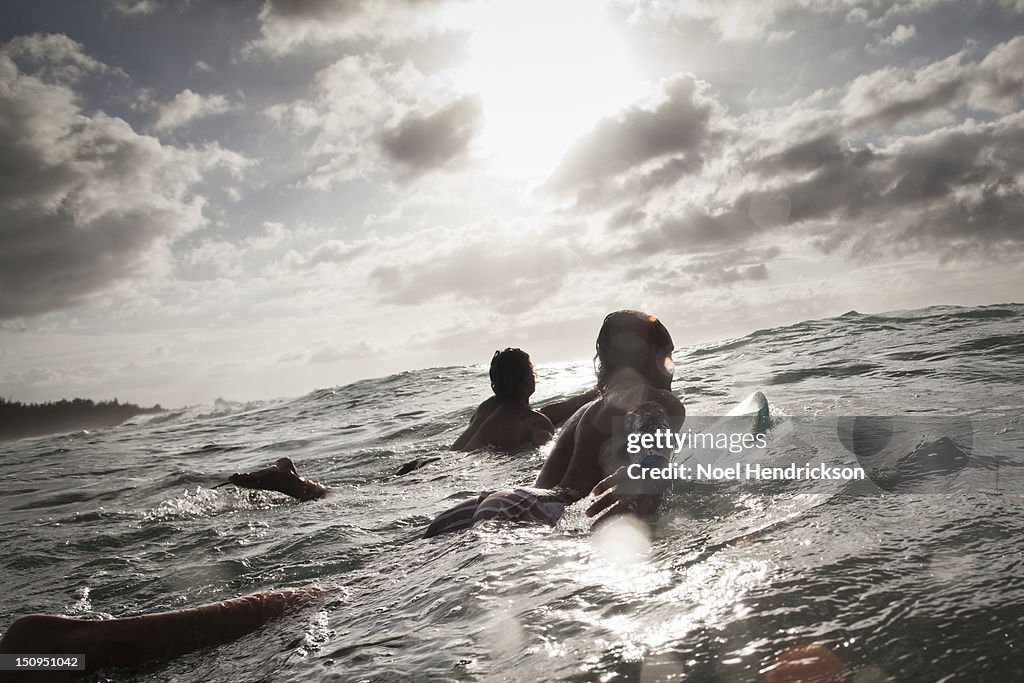 Two surfers paddle out to catch waves