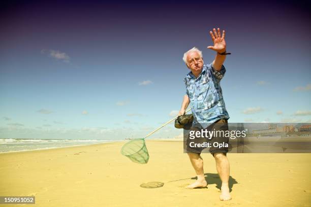 senior turista sulla spiaggia - solo un uomo anziano foto e immagini stock