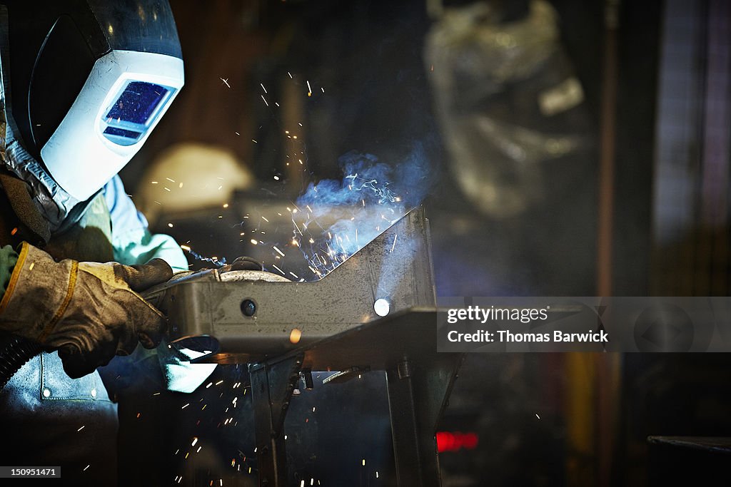 Welder working in steel manufacturing facility
