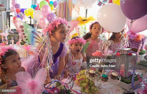 girl blowing out birthday candle - kids birthday party foto e immagini stock