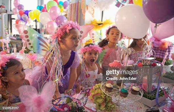 girl blowing out birthday candle - birthday party stockfoto's en -beelden