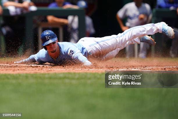 Drew Waters of the Kansas City Royals slides in home plates to score during the second inning against the Los Angeles Dodgers at Kauffman Stadium on...