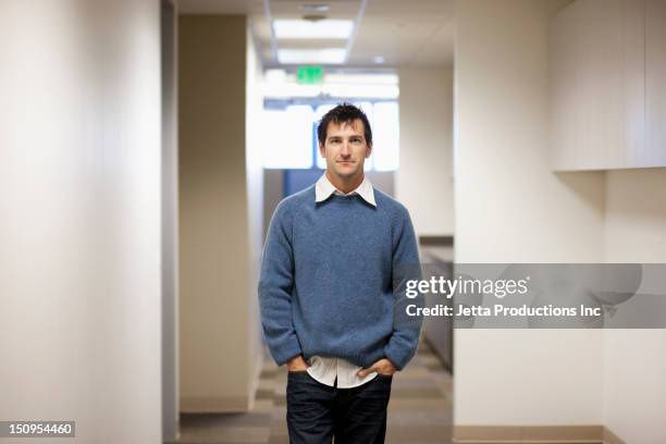 caucasian businessman standing in office - camisa hacia afuera fotografías e imágenes de stock