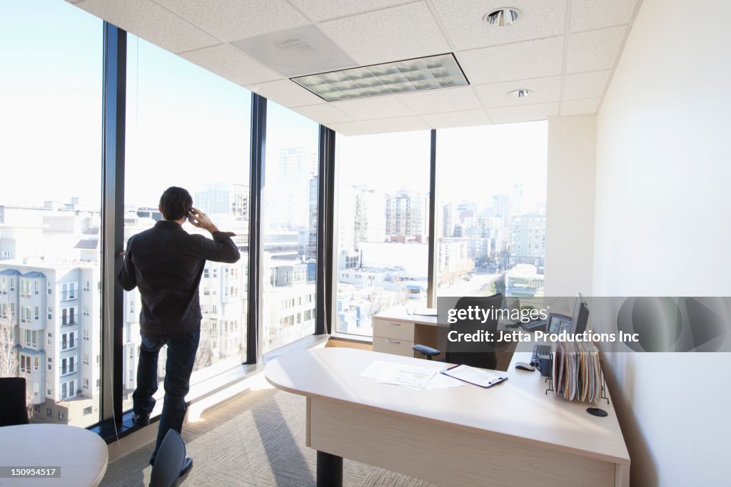 Caucasian businessman talking on cell phone in office