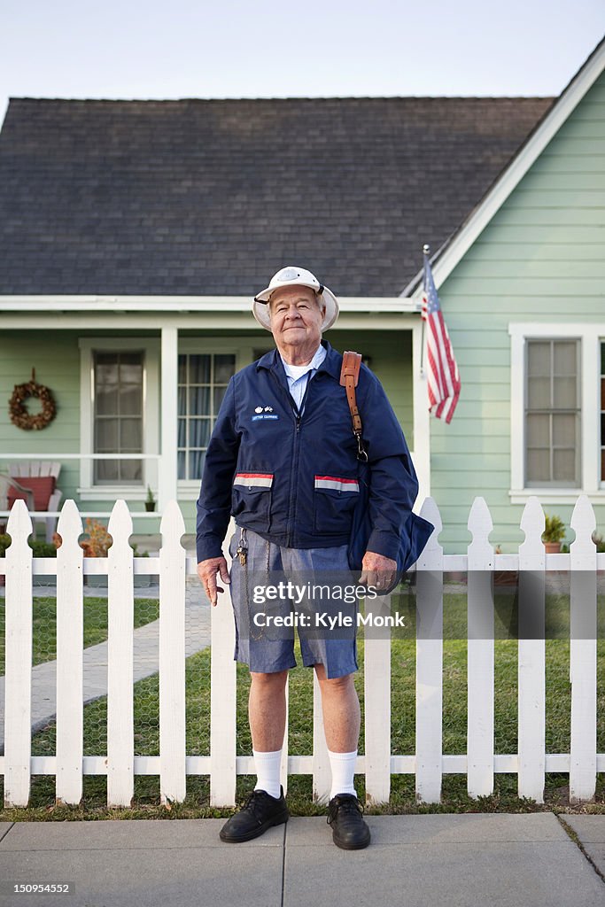 Caucasian mailman standing on sidewalk