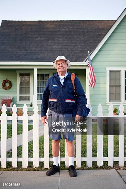 caucasian mailman standing on sidewalk - carteiro imagens e fotografias de stock