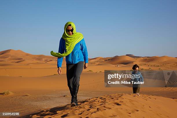 mother and son walking in desert - north africa photos et images de collection