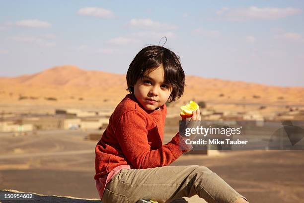mixed race boy eating fruit - alleen jongens stockfoto's en -beelden