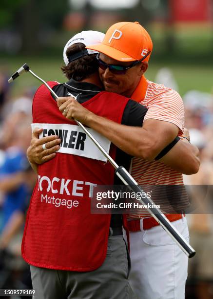 Rickie Fowler of the United States celebrates with his caddie, Ricky Romano, on the 18th green after winning on the first playoff hole during the...
