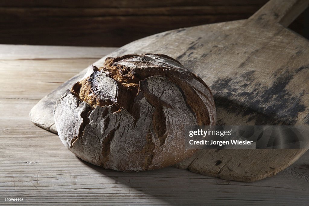 Freshly baked farmhouse bread on an old bread slide