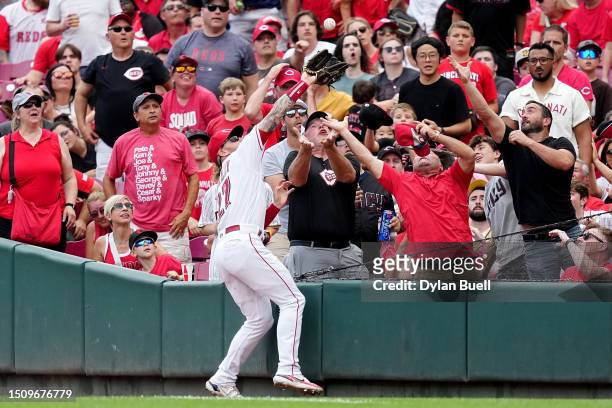 Jake Fraley of the Cincinnati Reds makes a catch next to fans in the sixth inning against the San Diego Padres at Great American Ball Park on July...