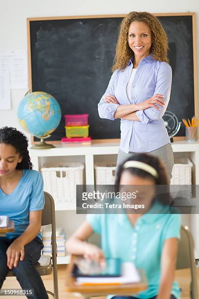 usa, new jersey, jersey city, portrait of female teacher in classroom with schoolgirls (10-13) - tetra images teacher stock pictures, royalty-free photos & images