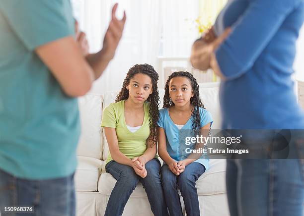 usa, new jersey, jersey city, parents quarreling, with daughters (10-13) in background - divorce kids fotografías e imágenes de stock