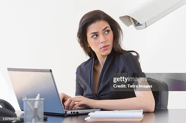 businesswoman spied on by cctv camera - workplace surveillance stock pictures, royalty-free photos & images
