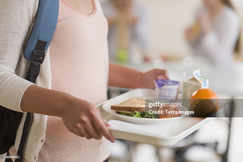 USA, New Jersey, Jersey City, Female student carrying tray in cafeteria