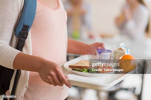 usa, new jersey, jersey city, female student carrying tray in cafeteria - comedor fotografías e imágenes de stock