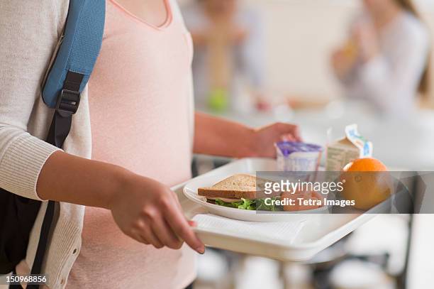 usa, new jersey, jersey city, female student carrying tray in cafeteria - cafeteria photos et images de collection