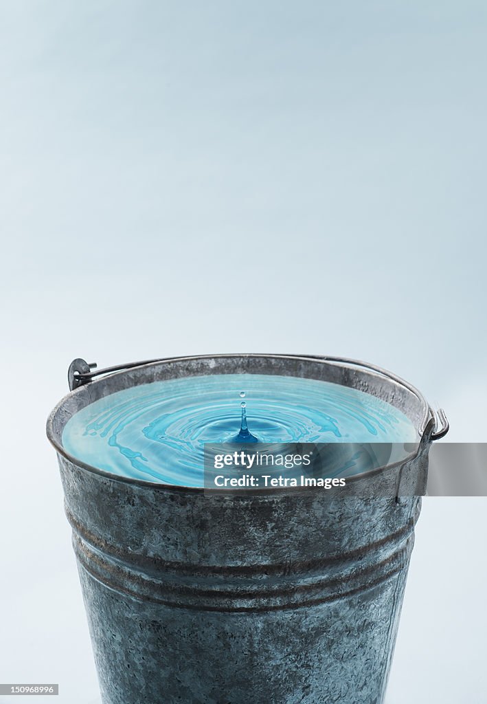 Drop falling into water in bucket