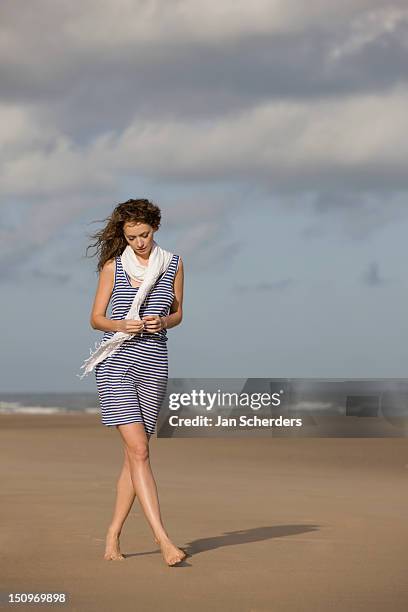 france, pas-de-calais, escalles, young woman strolling on empty beach - frau kleid stock-fotos und bilder