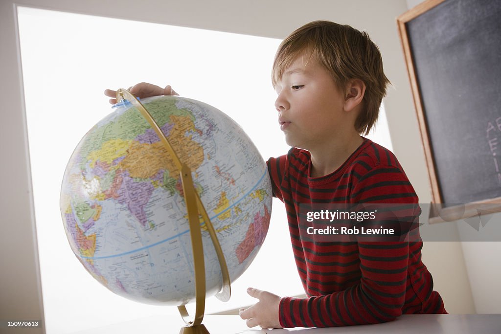 USA, California, Los Angeles, Schoolboy (6-7) with globe