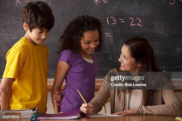 usa, california, los angeles, teacher explaining exercise to schoolgirl (10-11) and schoolboy (12-13) - showing appreciation stock pictures, royalty-free photos & images