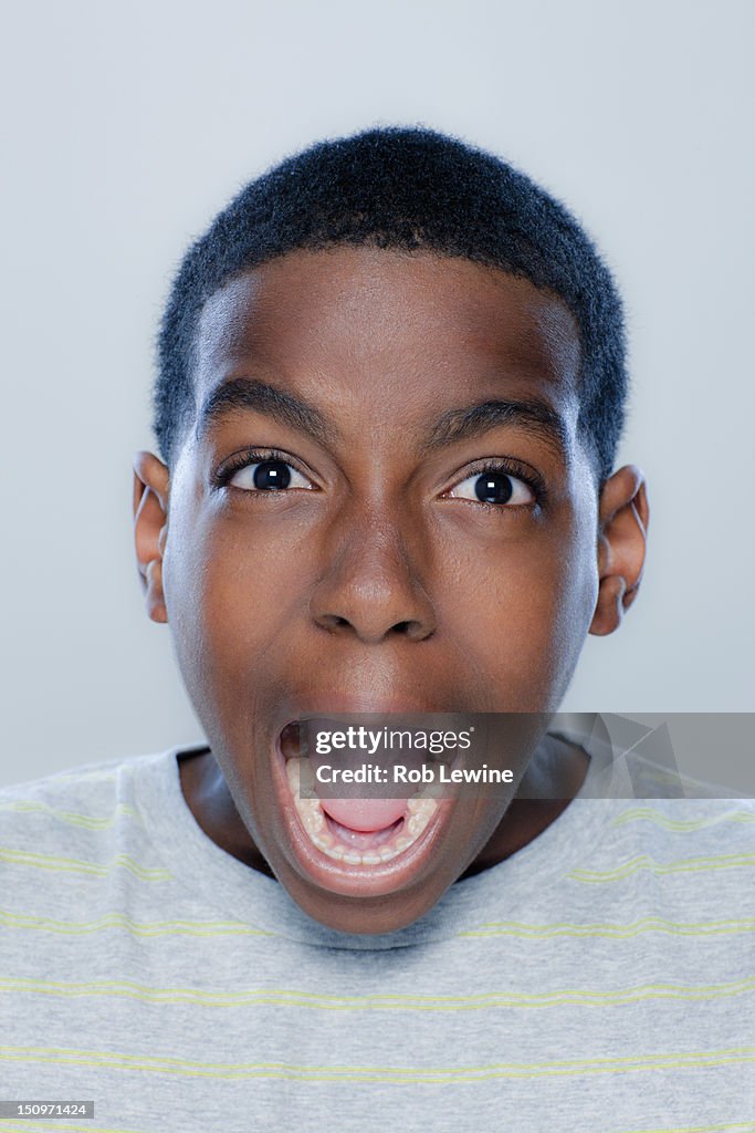 Portrait of teenage boy (14-15) screaming, studio shot