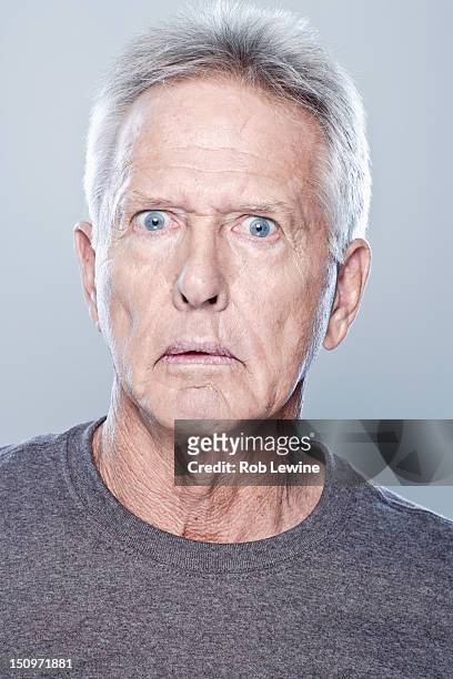 portrait of shocked senior man, studio shot - scared portrait stock-fotos und bilder