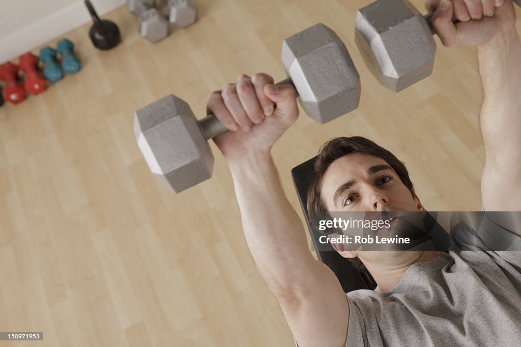 USA, California, Los Angeles, Young man exercising with dumbbell