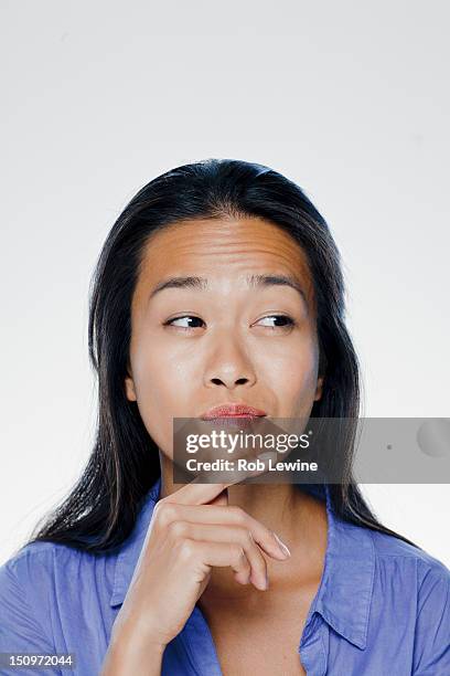 portrait of confused young woman, studio shot - 感情表現シリーズ ストックフォトと画像