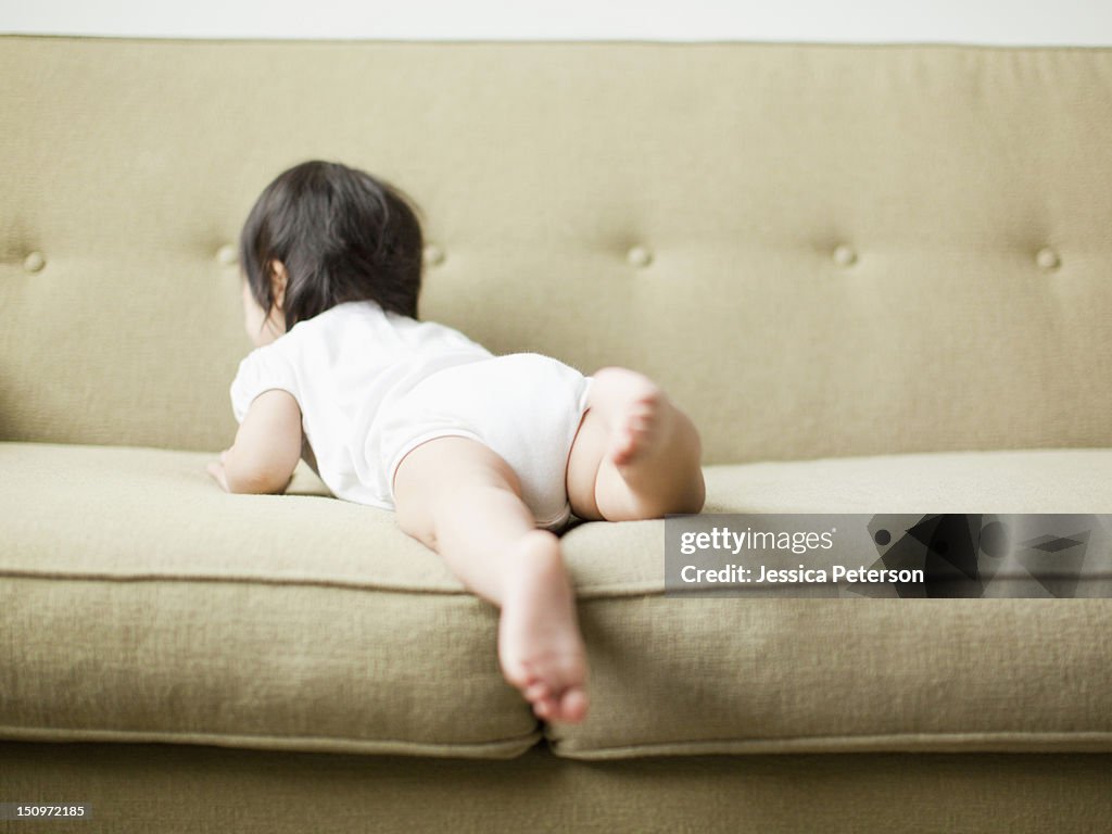 USA, Utah, Salt Lake City, Baby girl (12-17 months) crawling on sofa