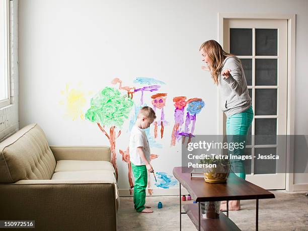 usa, utah, salt lake city, mother telling toddler boy (2-3) off for painting on walls - schreeuwen stockfoto's en -beelden