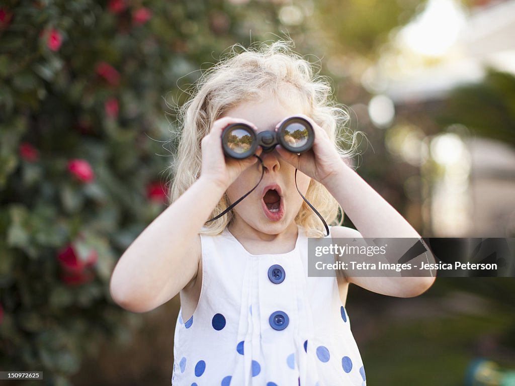 USA, California, Los Angeles, Surprised young girl (4-5) looking through binoculars