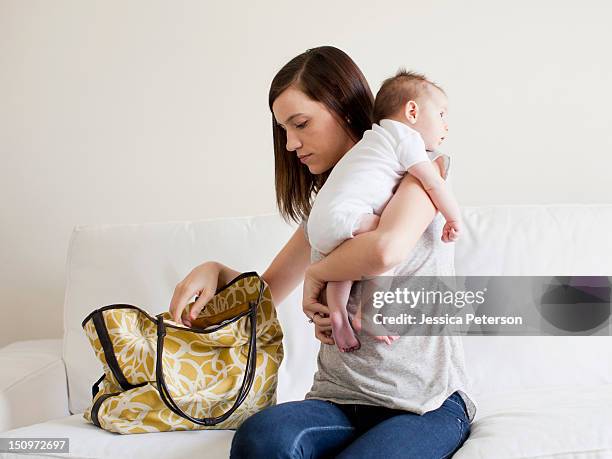 mother reaching in her handbag white embracing baby girl (2-5 months) - baby bag stock-fotos und bilder