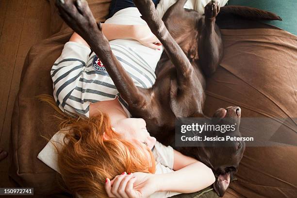 usa, utah, salt lake city, young woman and her dog sleeping on sofa - side by side stock pictures, royalty-free photos & images