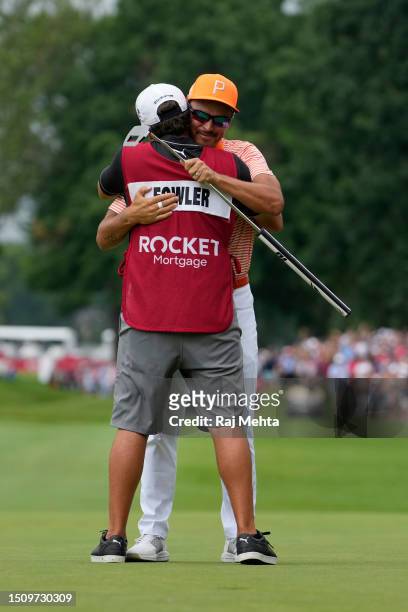 Rickie Fowler of the United States and his caddie, Ricky Romano, celebrate on the 18th green after defeating Adam Hadwin of Canada and Collin...