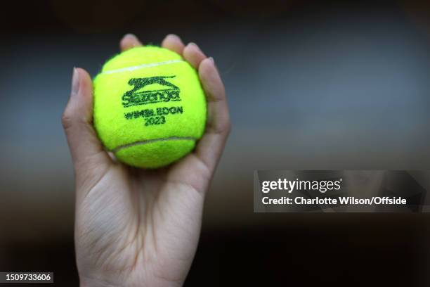 Tournament tennis ball is held up in a hand during day four of The Championships Wimbledon 2023 at All England Lawn Tennis and Croquet Club on July...