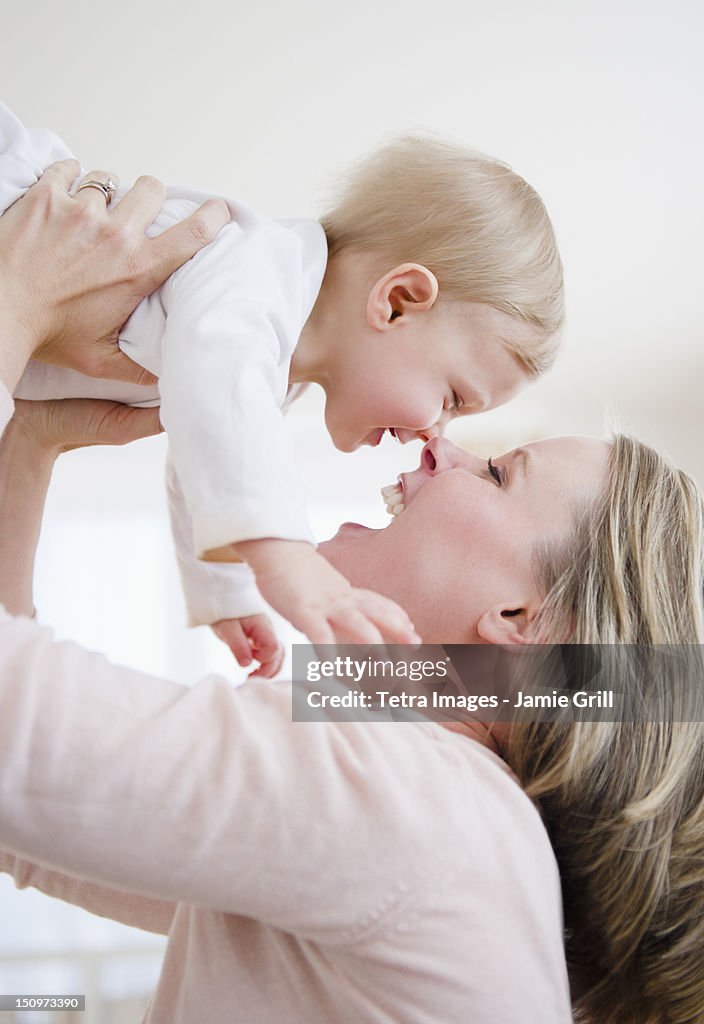 USA, New Jersey, Jersey City, Mother lifting son (6-11 months)
