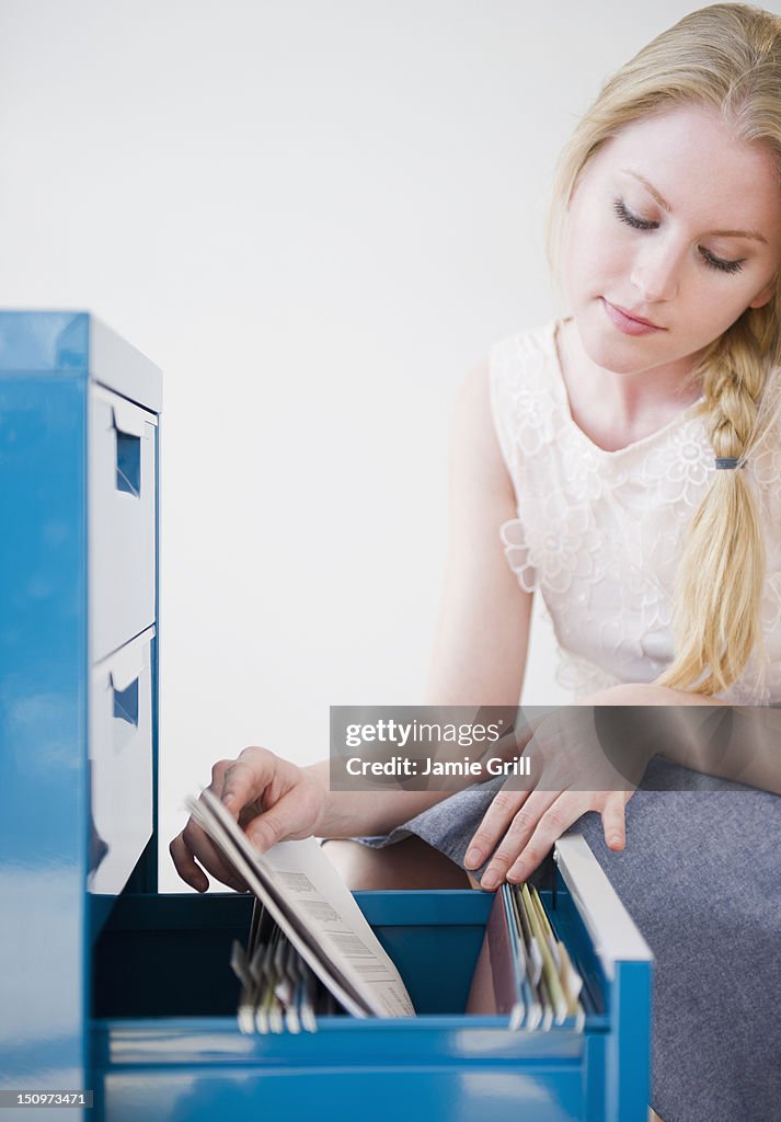 USA, New Jersey, Jersey City, Woman looking into file cabinet